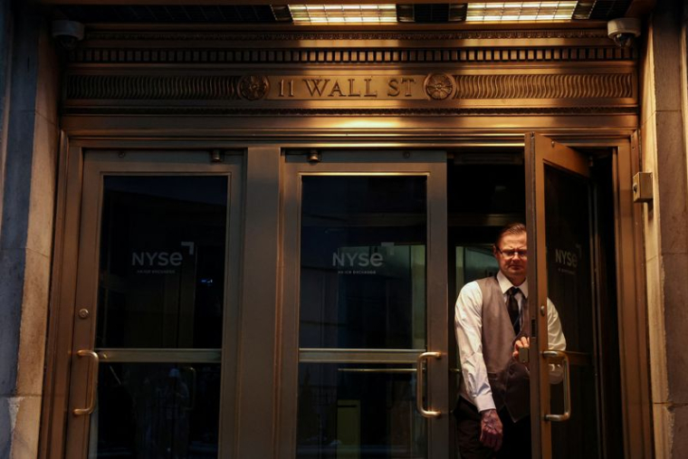 Un homme sort de la Bourse de New York (NYSE) sur Wall Street à New York