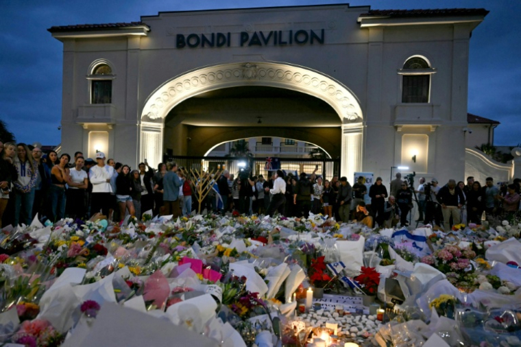 Des personnes se recueillent devant le Bondi Pavillion en hommage aux victimes d'un attentat à Bondi Beach, le 15 décembre 2025 à Sydney, en Australie ( AFP / Saeed KHAN )