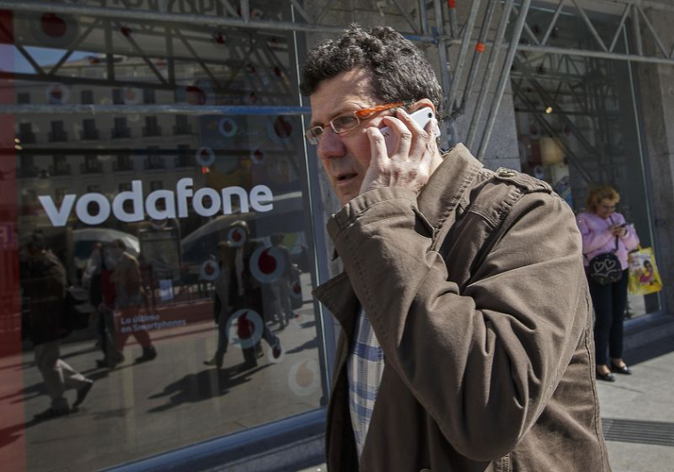 Un homme, au téléphone portable, passe devant une boutique Vodafone dans le centre de Madrid
