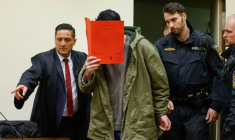 L'Afghan Farhad N., le visage caché derrière un dossier, arrive au tribunal avec son avocat Omer Sahinci (g), le 16 janvier 2026 à Munich, pour le début de son procès pour avoir foncé en voiture dans la foule à Munich en 2025  ( AFP / Michaela Stache )