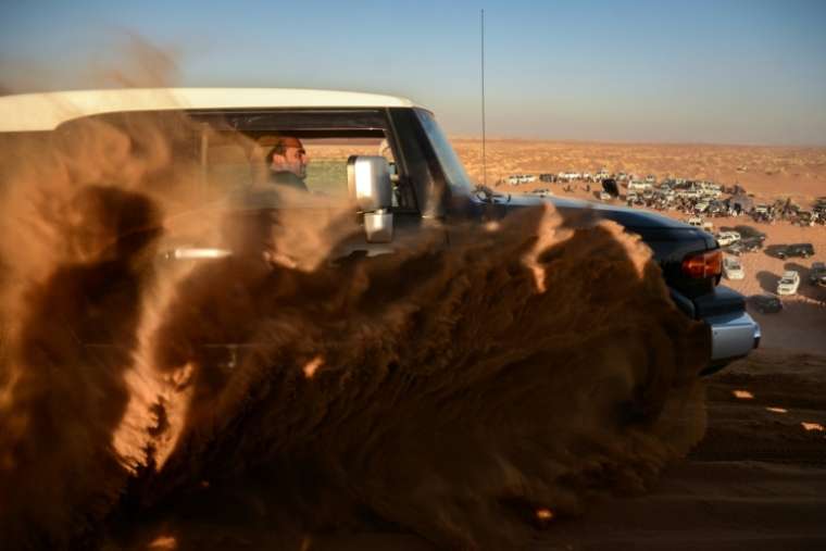 Un passionné d'automobile conduit un 4X4 dans les dunes de la province de Kandahar, le 5 décembre 2025 en Afghanistan ( AFP / Sanaullah SEIAM )