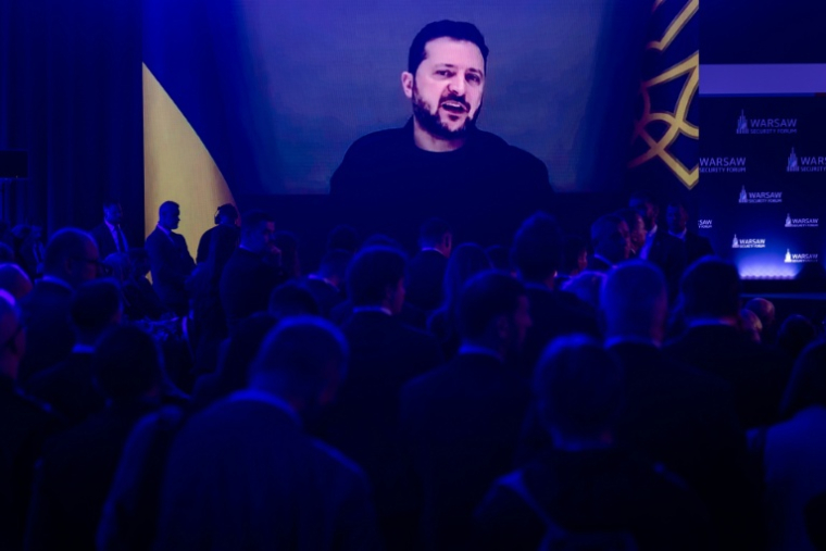 Les participants à un forum sur la sécurité à Varsovie écoutent le président ukrainien Volodymyr Zelensky par visioconférence le 12 octobre 2026 ( AFP / Wojtek RADWANSKI )
