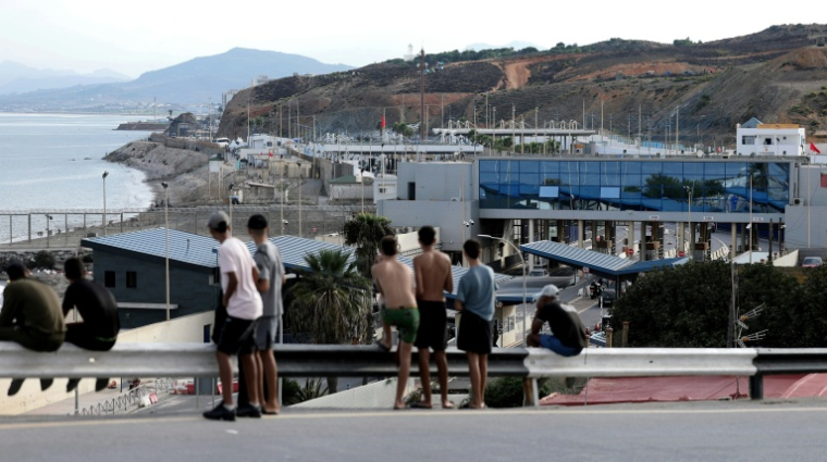 Des migrants observent la frontière avec le Maroc depuis l'enclave espagnole de Ceuta, le 11 octobre 2026 ( AFP / Thomas COEX )