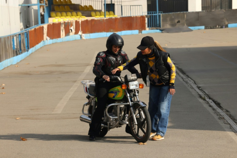 La monitrice Maryam Ghelich (g) pendant un cours de conduite avec son élève Leila dans un centre d'entraînement du nord de Téhéran, le 7 décembre 2025 en Iran ( AFP / ATTA KENARE )