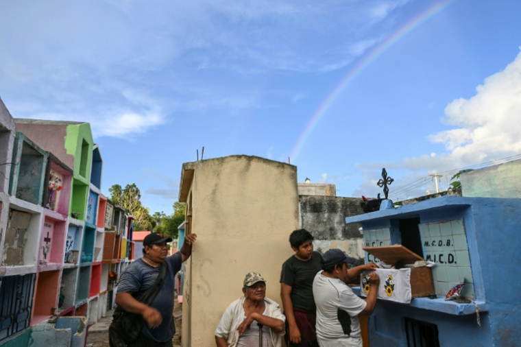 Des personnes se préparent à nettoyer les restes d'un proche avant les célébrations du Jour des Morts au cimetière de Pomuch, dans l'État de Campeche, au Mexique, le 18 octobre 2025 ( AFP / Yuri CORTEZ )