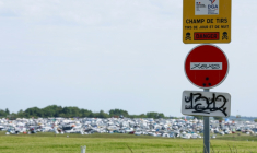 Un panneau "Champ de tirs" sur le site de la free party organisée illégalement à Cornusse, dans le Cher, le 2 mai 2026 ( AFP / Kenzo TRIBOUILLARD )