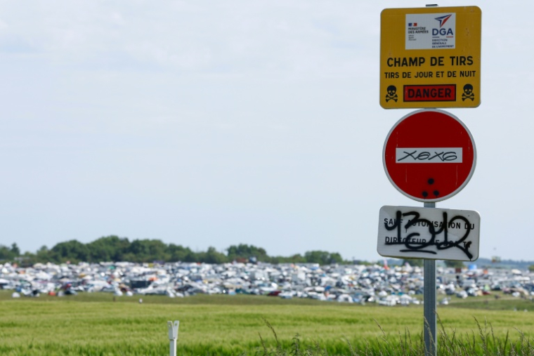 Un panneau "Champ de tirs" sur le site de la free party organisée illégalement à Cornusse, dans le Cher, le 2 mai 2026 ( AFP / Kenzo TRIBOUILLARD )