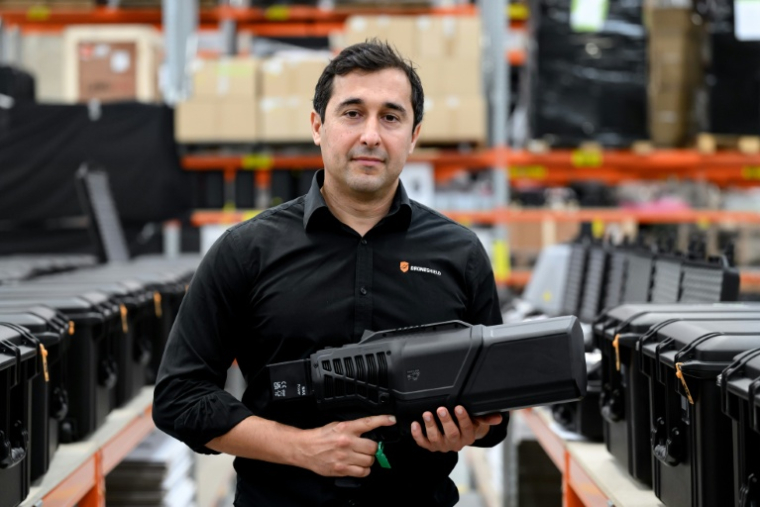 Oleg Vornik, PDG de DroneShield, tient un "DroneGun Mk4" lors d'une visite de l'entreprisede défense à Sydney, le 9 février 2026 en Australie ( AFP / STEVEN MARKHAM )