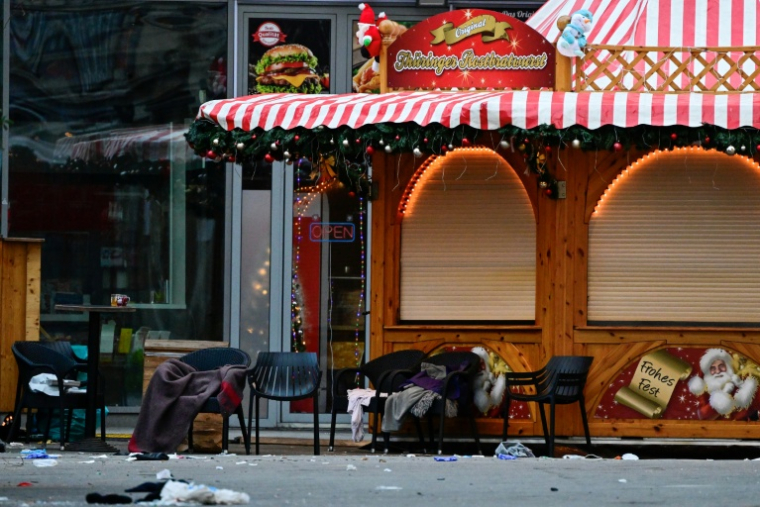 Des chaises vides, des couvertures abandonnées et des débris sur un marché de Noël fermé, où une voiture a foncé dans la foule la veille au soir, le 21 décembre 2024 à Magdebourg, dans l'est de l'Allemagne ( AFP / John MACDOUGALL )