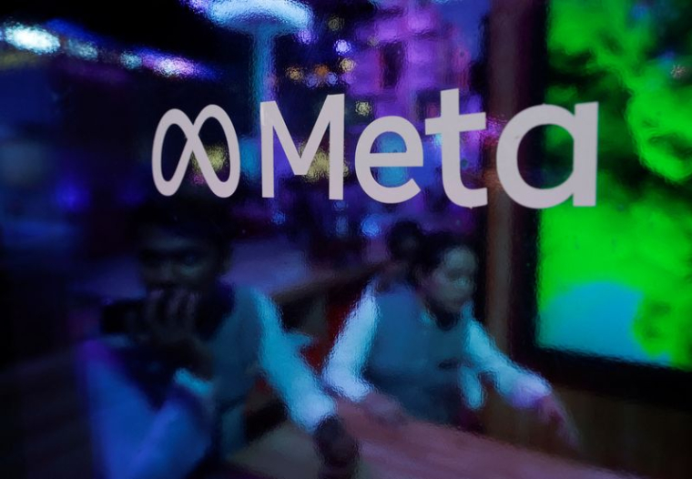 Des personnes sont vues derrière un logo de Meta Platforms, lors d'une conférence à Mumbai