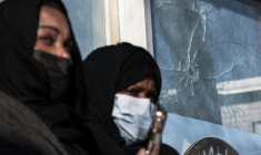 Deux femmes américano-somaliennes se tiennent, le 26 janvier 2026, devant une fenêtre brisée par des impacts de balle survenus, selon le propriétaire de l’établissement, lorsque Alex Pretti a été abattu par des agents fédéraux à Minneapolis ( AFP / ROBERTO SCHMIDT )