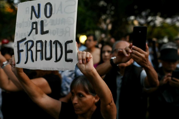 Un manifestant brandit une pancarte sur laquelle on peut lire "Non à la fraude" en espagnol, lors d'une manifestation devant le siège du Jury national des élections (JNE) à Lima, le 14 avril 2026 ( AFP / ERNESTO BENAVIDES )