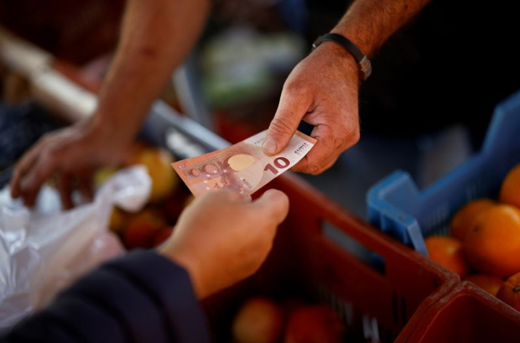 Un client paie avec un billet de dix euros dans un marché local à Nantes