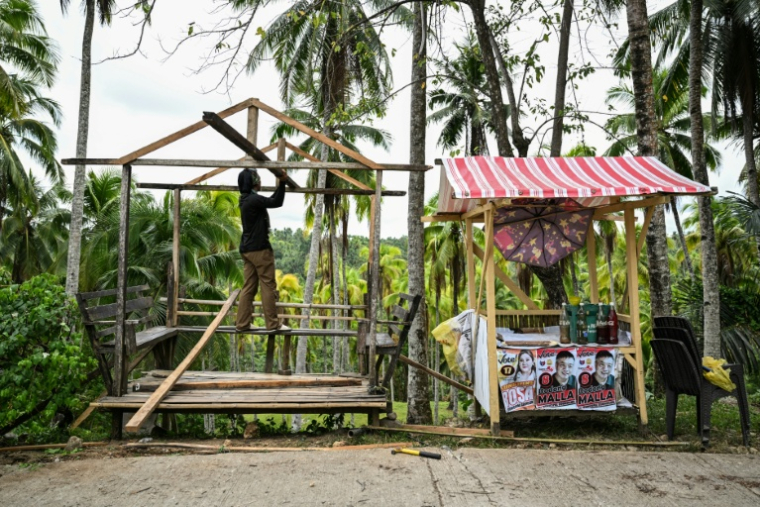 Un homme reconstruit un abri à Manay après deux puissants séismes dans le sud des Philippines, le 11 octobre 2025 ( AFP / Jam STA ROSA )