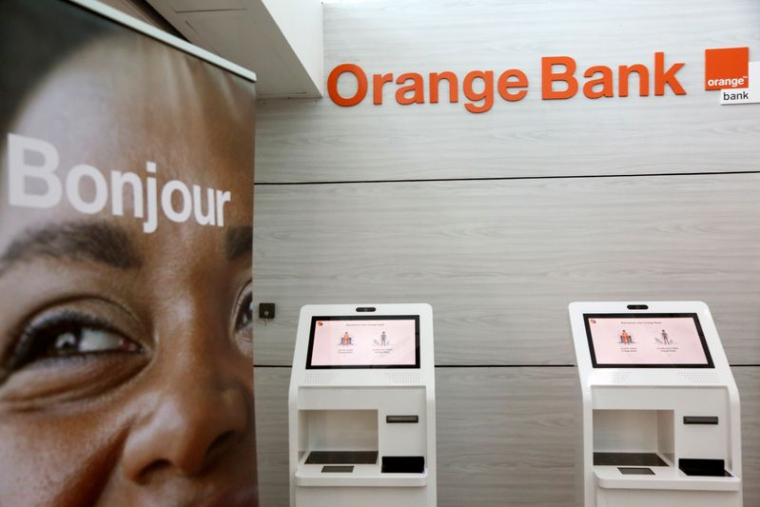 Des distributeurs automatiques sont visibles dans une banque de l'opérateur mobile français Orange à Abidjan