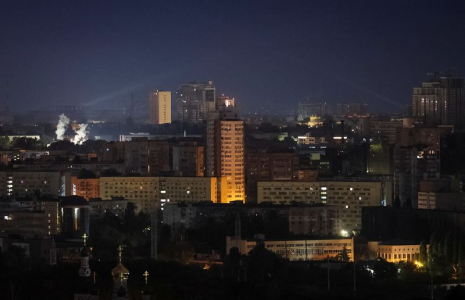 Le personnel des services ukrainiens utilise un projecteur pour rechercher des drones dans le ciel de la ville lors d'une attaque de missiles et de drones russes, à Kyiv