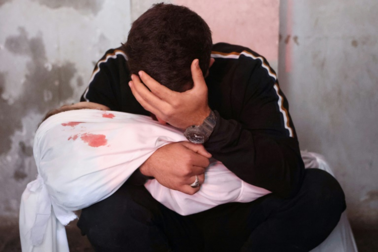 Un Palestinien pleure en tenant le corps d'un enfant tué lors d'une frappe israélienne, dans la ville de Gaza, le 6 avril 2025 ( AFP / Omar AL-QATTAA )
