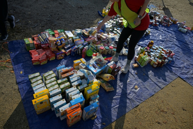 Des bénévoles de l'association People's Pantry Food déposent des denrées alimentaires lors d'une récolte devant le ministère américain de l'Agriculture, à Washington, le 30 octobre 2025 ( AFP / Oliver Contreras )