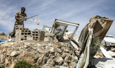 Un Palestinien récupère des objets dans les décombres d'une maison démolie dans le hameau de Khallet Al-Dabaa, en Cisjordanie occupée, le 6 mai 2025, après la destruction par les forces israéliennes des habitations de ce village ( AFP / JOHN WESSELS )