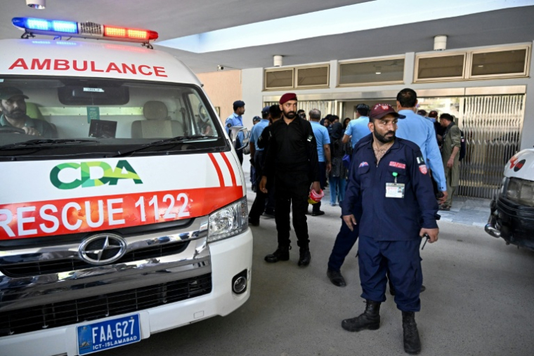 Des agents de sécurité se tiennent près d'une ambulance après un incendie à l'hôpital PIMS, à Islamabad, qui a coûté la vie à 14 nourrissons, le 26 août 2026. ( AFP / Aamir QURESHI )