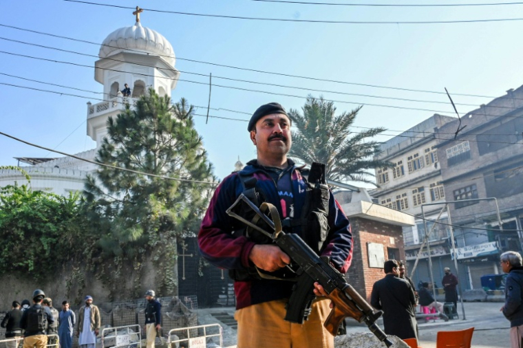 Un policier monte la garde devant l'église All Saints de Peshawar à l'occasion de Noël, le 25 décembre 2025 au Pakistan ( AFP / Abdul MAJEED )