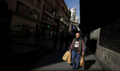 Un homme porte des sacs dans un quartier commerçant du centre-ville de Madrid
