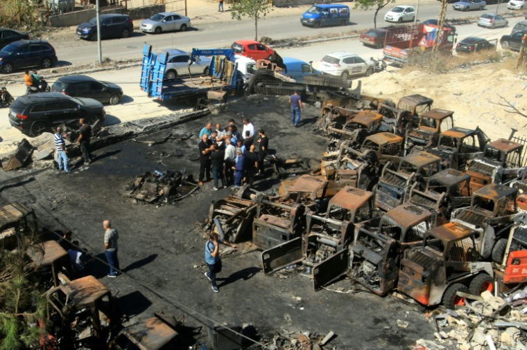 Des personnes se tiennent au milieu de matériels agricoles calcinés, sur le site d'une frappe israélienne nocturne dans le village de Msaileh, au sud du Liban, le 11 octobre 2025 ( AFP / MAHHMOUD ZAYYAT )