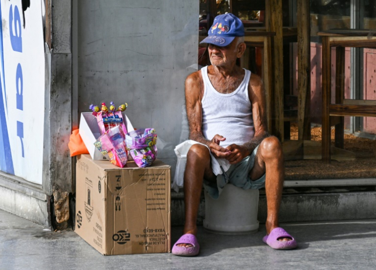 Un homme âgé vend des bonbons dans une rue de La Havane, le 3 juin 2025 ( AFP / YAMIL LAGE )
