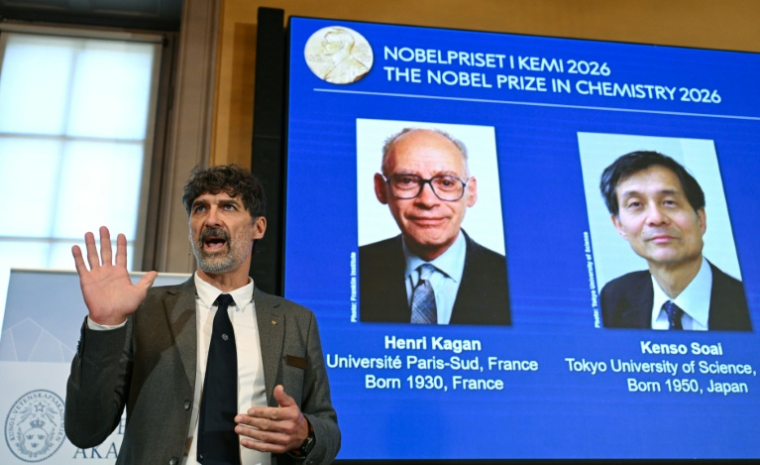 Heiner Linke (g), président du comité Nobel de chimie, à côté d'un écran affichant les portraits des lauréats, le Français Henri Kagan et le Japonais Kenso Soai à l'Académie royale des sciences de Suède, à Stockholm, le 7 octobre 2026 ( AFP / Jonathan Nackstrand )