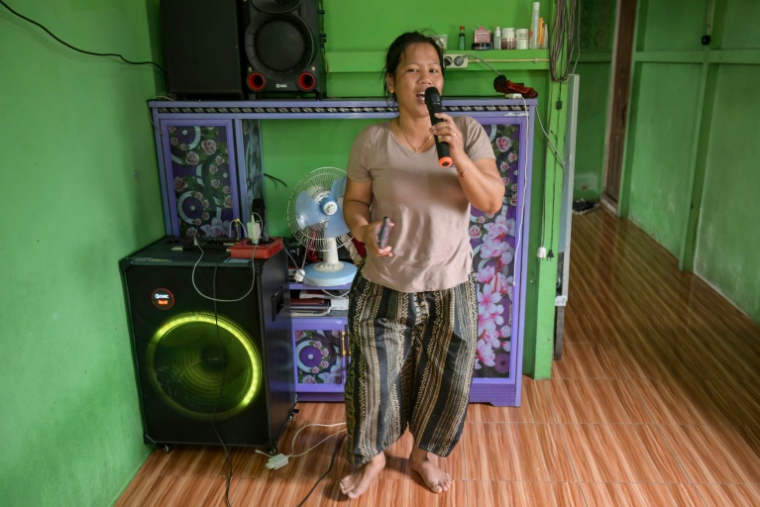 Une observatrice de la faune pour Borneo Future Indonesia,  Katarina Siti, en train de chanter avec une machine de karaoké qu’elle a achetée avec l’argent gagné en observant la faune dans le village de Sungai Ajung, à Kapuas Hulu, à Bornéo, le 2 septembre 2026 ( AFP / BAY ISMOYO )