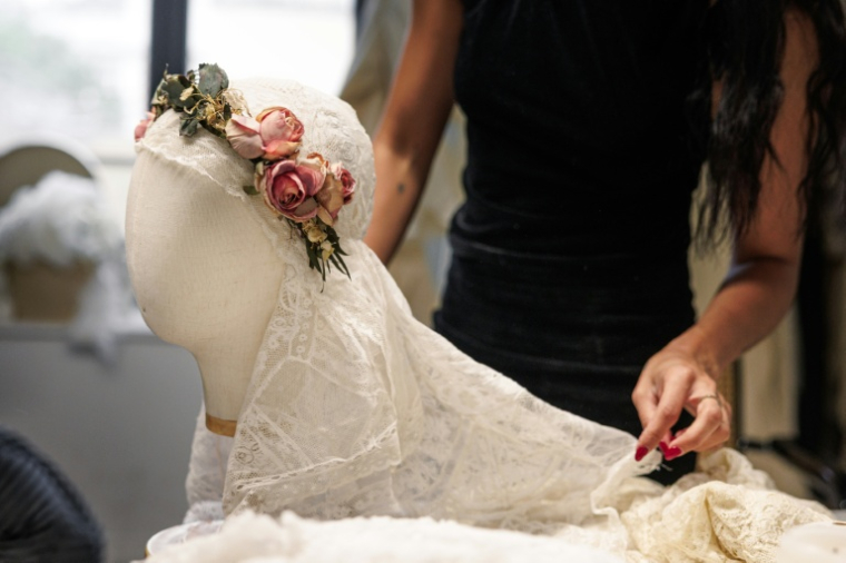 La créatrice, directrice artistique et styliste espagnole Maria Bernad, fondatrice de l'atelier Les Fleurs Studio, travaille sur une pièce réalisée à partir de dentelles anciennes, le 5 mai 2026 à Paris ( AFP / SIMON WOHLFAHRT )