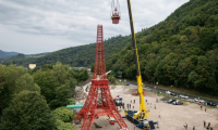 Des ouvriers installent la flèche d'une réplique à l'échelle 1/10e de la Tour Eiffel, construite par l'entrepreneur alsacien Jean-Claude Fassler, à Sainte-Croix-aux-Mines, dans le Haut-Rhin, le 26 août 2025 ( AFP / SEBASTIEN BOZON )