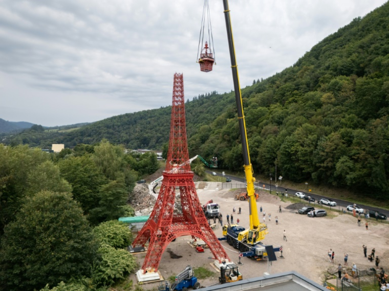 Des ouvriers installent la flèche d'une réplique à l'échelle 1/10e de la Tour Eiffel, construite par l'entrepreneur alsacien Jean-Claude Fassler, à Sainte-Croix-aux-Mines, dans le Haut-Rhin, le 26 août 2025 ( AFP / SEBASTIEN BOZON )