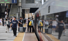 Des passagers montent à bord d'un TGV dans une gare de Dalian, Nord-Est de la Chine, le 1er juillet 2025. ( AFP / STR )