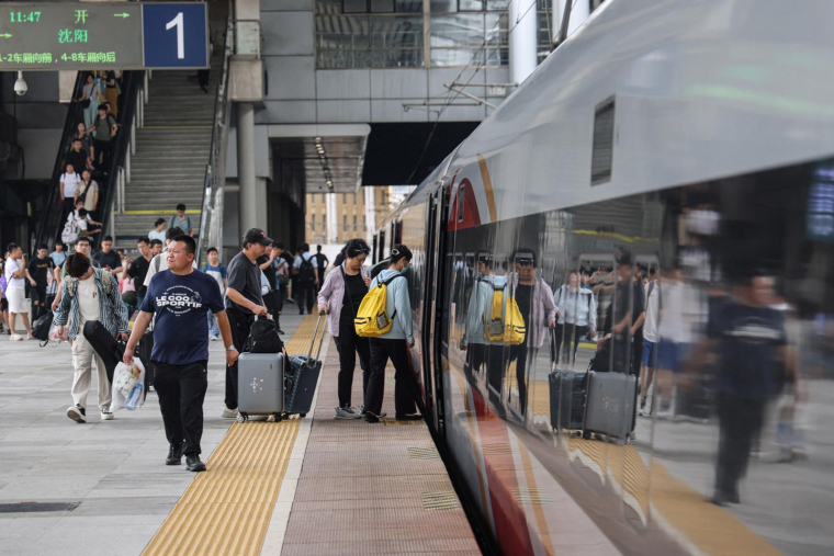 Des passagers montent à bord d'un TGV dans une gare de Dalian, Nord-Est de la Chine, le 1er juillet 2025. ( AFP / STR )