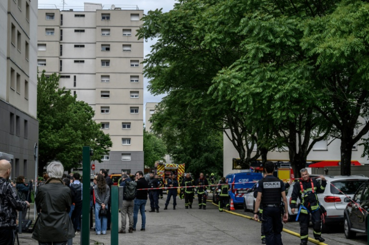 Des policiers et des pompiers sur le site d'un incendie qui s'est déclaré dans un immeuble résidentiel à Décines-Charpieu, en périphérie de Lyon, le 11 mai 2026 ( AFP / JEFF PACHOUD )
