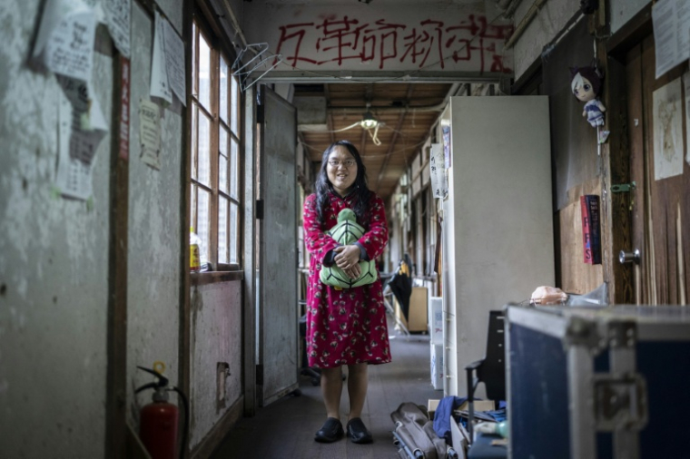 L'étudiante Masako Ueda, résidente du Foyer Yoshida de l'université de Kyoto, dans un couloir avec sa peluche préférée, une tortue, le 4 février 2026 au Japon ( AFP / Yuichi YAMAZAKI )