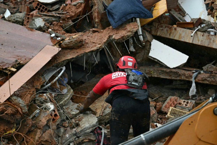 Un secouriste recherche des victimes d'un glissement de terrain provoqué par de fortes pluies à Juiz de Fora, dans l'État du Minas Gerais, au Brésil, le 24 février 2026 ( AFP / Pablo PORCIUNCULA )