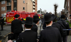 Des habitants sont rassemblés près d'un camion de pompiers après une attaque "antisémite" à Londres ayant visé quatre ambulances gérées par une association juive, le 23 mars 2026 ( AFP / Henry Nicholls )
