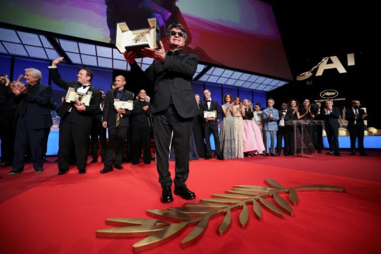 Jafar Panahi et sa Palme d'Or, à Cannes, le 24 mai 2025, pour le film "Un simple accident" ( AFP / Valery HACHE )