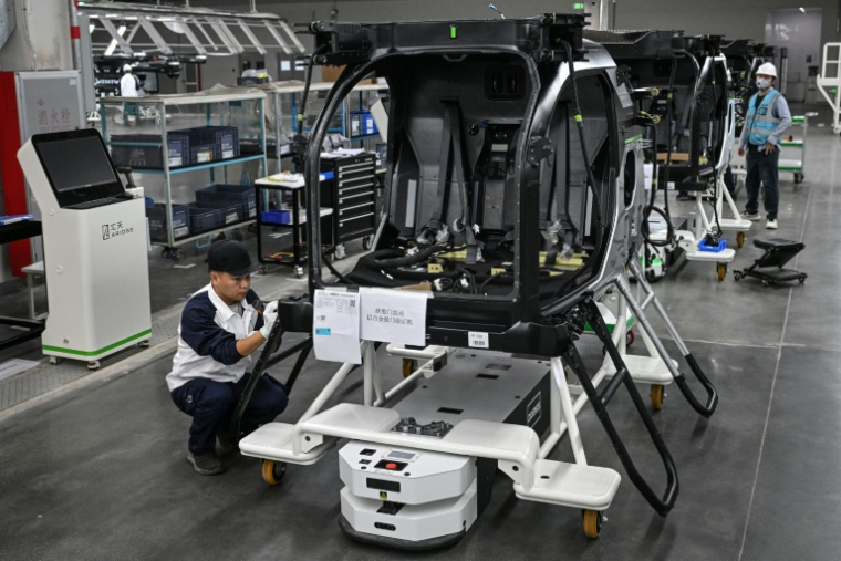 Des employés travaillent sur une chaîne de montage pour la voiture volante électrique "Land Aircraft Carrier" dans une usine de la filiale Aridge de Xpeng à Guangzhou, dans le sud de la Chine, le 6 novembre 2025 ( AFP / Jade GAO )