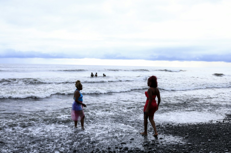 Des touristes sur la plage près de l'hôtel Seme Beach à Limbé, le 4 octobre 2025 au Cameroun ( AFP / Daniel BELOUMOU OLOMO )