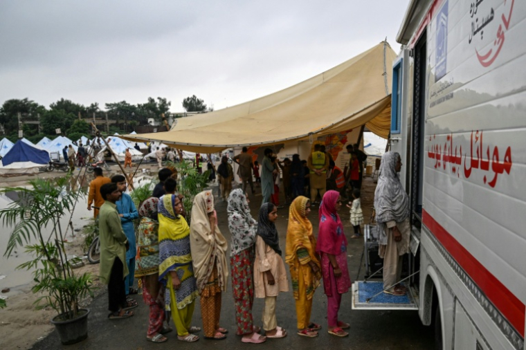 Des Pakistanaises évacuées après les crues au Pendjab attendent leur tour pour entrer dans un dispensaire mobile dans un camp de fortune dressé à Chung, le 31 août 2025 ( AFP / Aamir QURESHI )