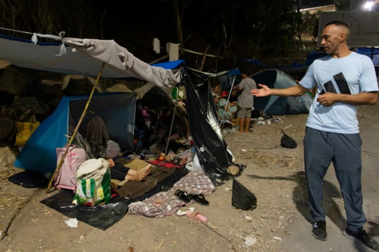 Le migrant marocain Otman Ianaya (d), 40 ans, monter où il dort avec sa famille dans un abri de fortune sur la plage d'El Trampolin à Ceuta, en Espagne, le 2 septembre 2026 ( AFP / Antonio Sempere )