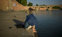 Un homme se protège du soleil, le 20 juin 2025 à Toulouse ( AFP / Ed JONES )