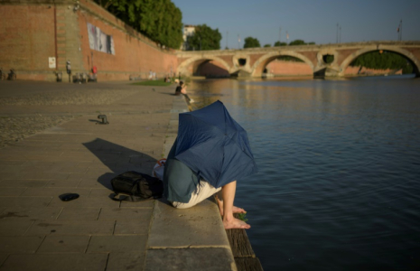 Un homme se protège du soleil, le 20 juin 2025 à Toulouse ( AFP / Ed JONES )