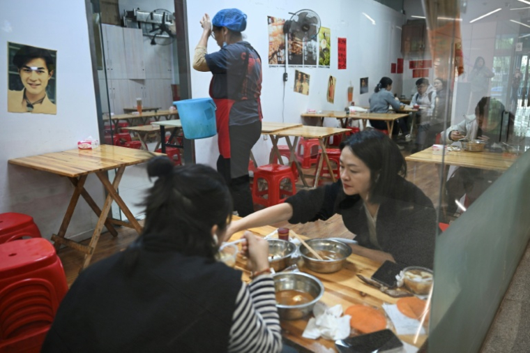 Des clients déjeunent dans un restaurant à Pékin, le 20 octobre 2025 ( AFP / Pedro PARDO )