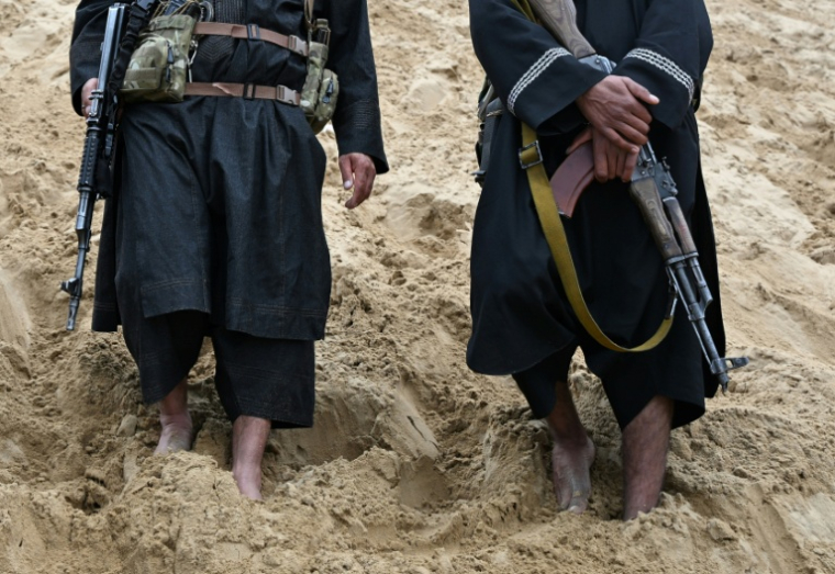 Des personnels de sécurité talibans surveillent le site de loisirs situé sur la pente sableuse de la montagne Reg-e-Rawan dans la région de Sayad, le 24 avril 2026, en Afghanistan ( AFP / Wakil KOHSAR )