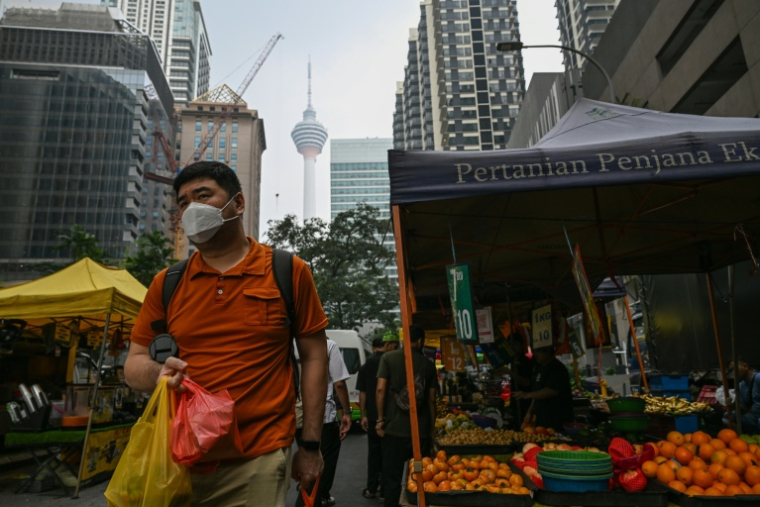 Un homme équipé d'un masque dans les rues de Kuala Lumpur polluées par les fumées toxiques issues des incendies en Indonésie, le 16 octobre 2026, en Malaisie ( AFP / Jam STA ROSA )