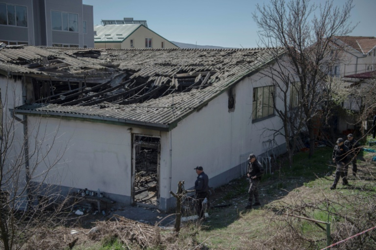Des policiers inspectent la discothèque ravagée par un incendie à Kocani, en Macédoine du Nord, le 19 2025 ( AFP / Armend NIMANI )